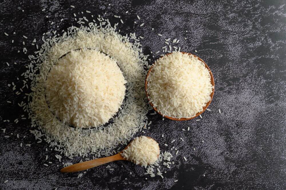 milled-rice-bowl-wooden-spoon-black-cement-floor